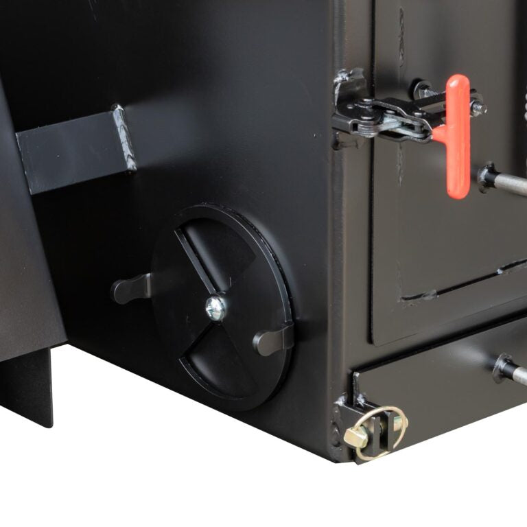 Close-up of a black metal appliance with a red handle and various mechanical components.