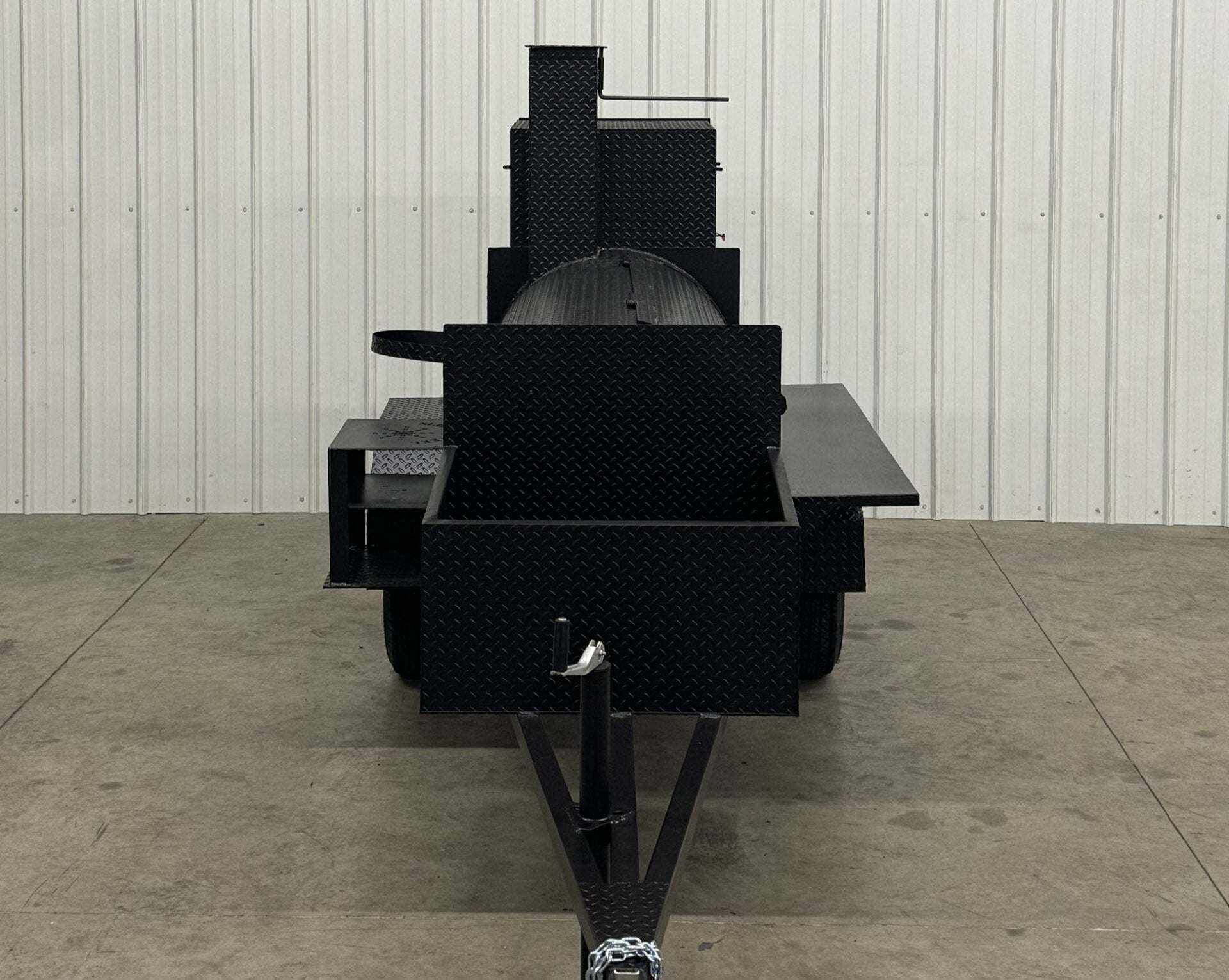 Front view of black Competition 60 Smoker barbeque smoker with large tank, rib box, insulated firebox, and fryer stand on concrete floor