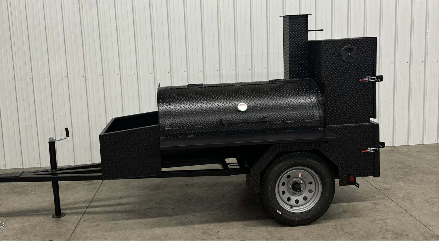 Competition 60 barbeque smoker with rolled tread steel tank, slide-out cooking racks, rib box, insulated firebox, storage basket, and fryer stand mounted on trailer.