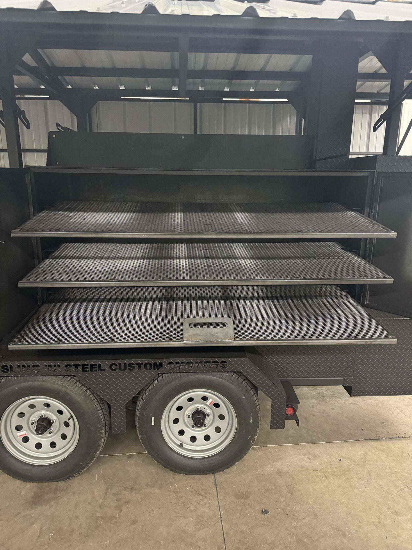 Commercial Custom Ultimate Smokehouse 72-inch reverse flow smoker with multiple pull-out cooking racks and charcoal grill on trailer