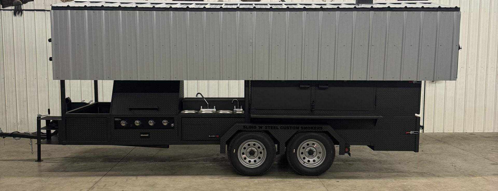 Custom Ultimate Smokehouse 72-inch commercial smoker trailer with griddle, sink, charcoal grill, and storage compartments