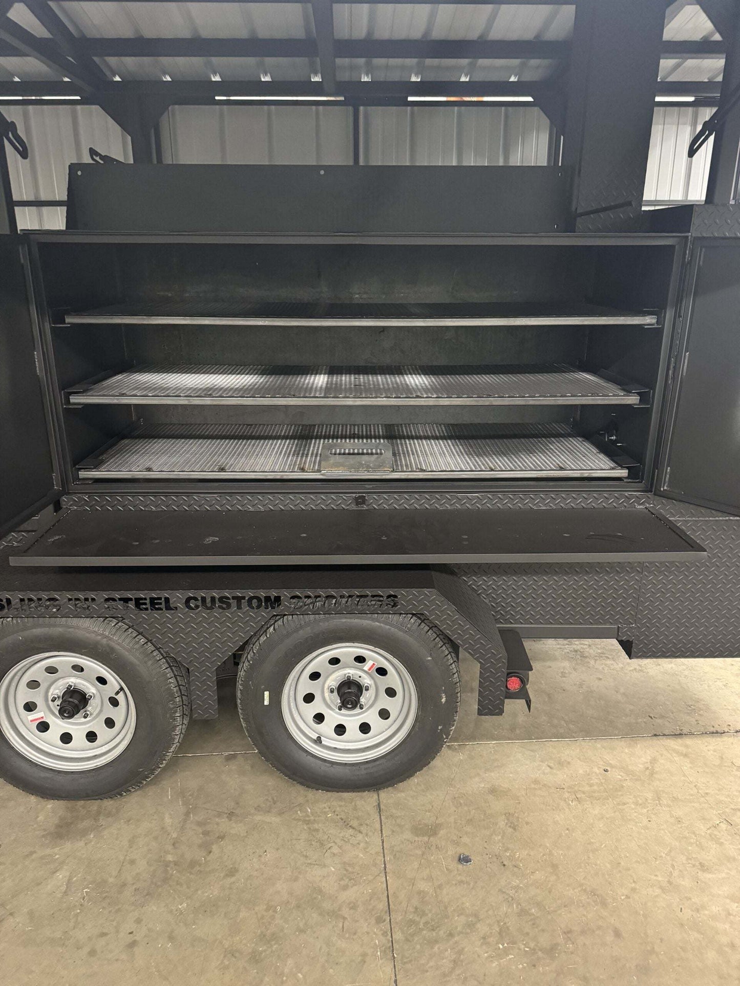Commercial Smoker Custom Ultimate Smokehouse 72-inch reverse flow smoker with three pull-out cooking racks and charcoal grill on trailer