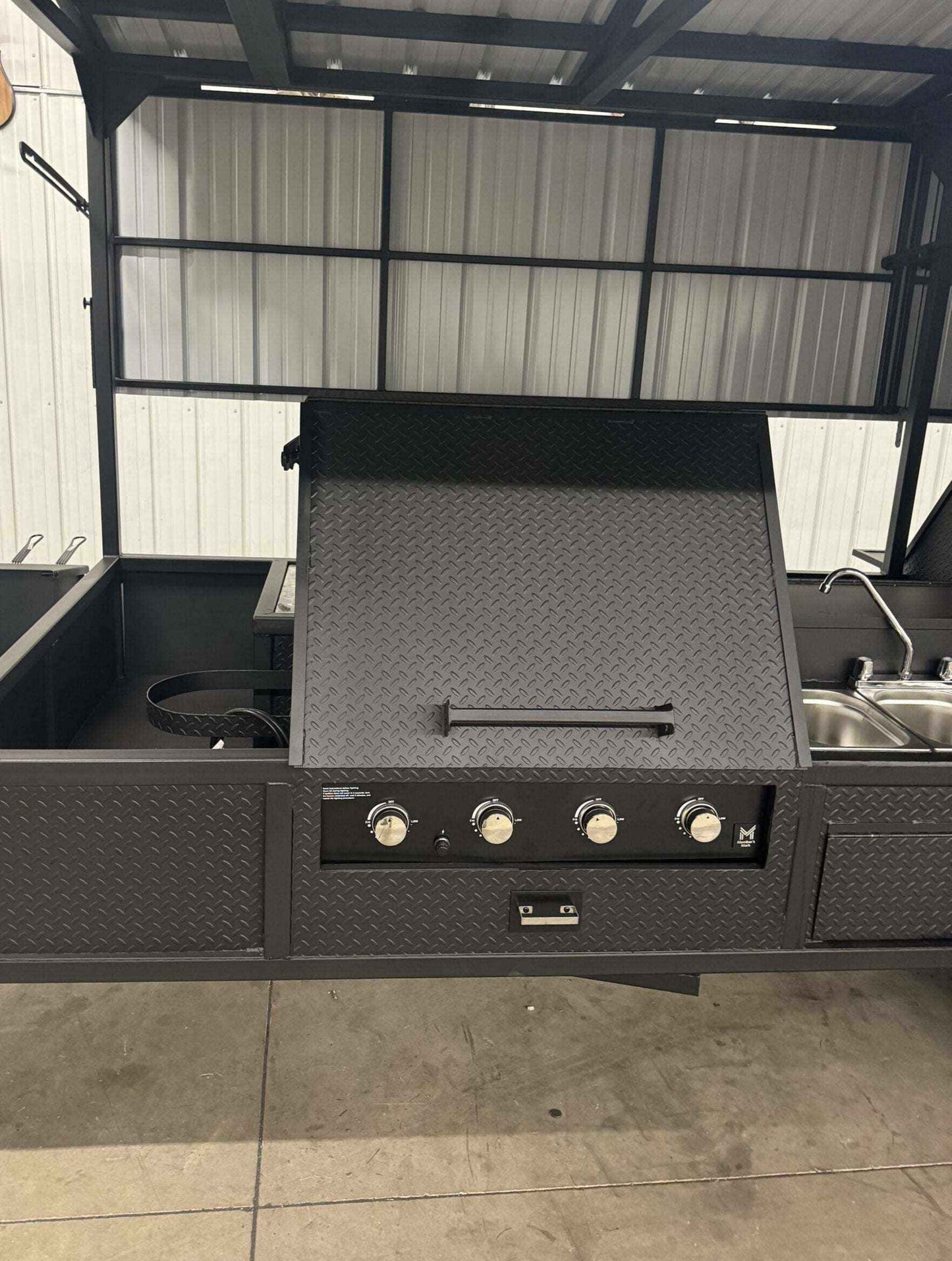 Custom Ultimate Smokehouse 72 commercial smoker with 36-inch griddle, four-bay sink package, and large charcoal grill in diamond tread steel design