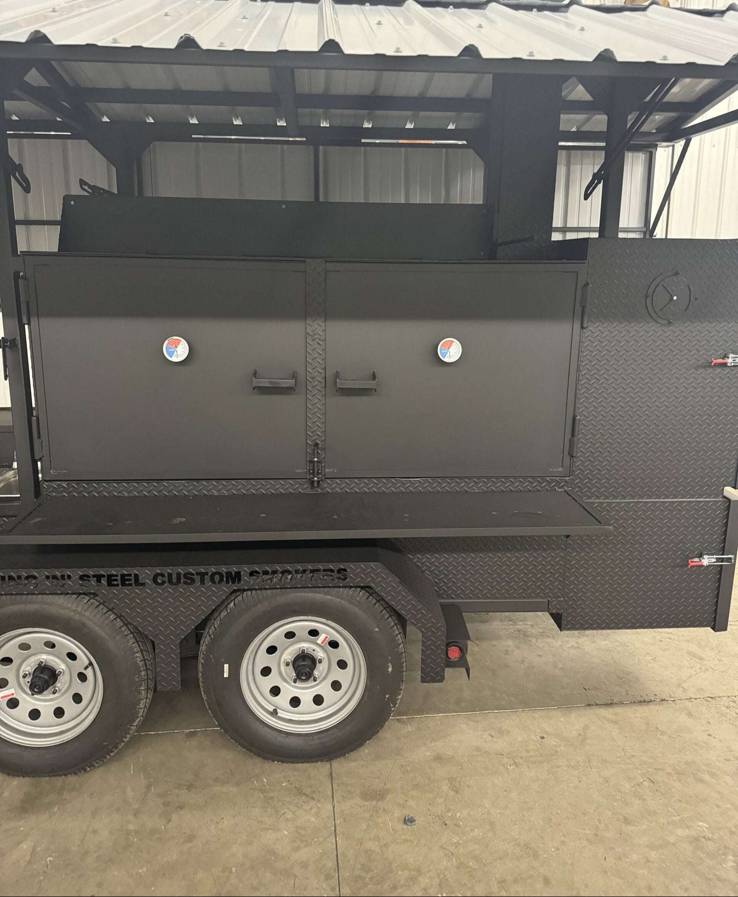 Commercial Smoker Custom Ultimate Smokehouse 72-inch charcoal grill with griddle, insulated firebox, multiple cooking racks, warming box, and sink package on trailer.