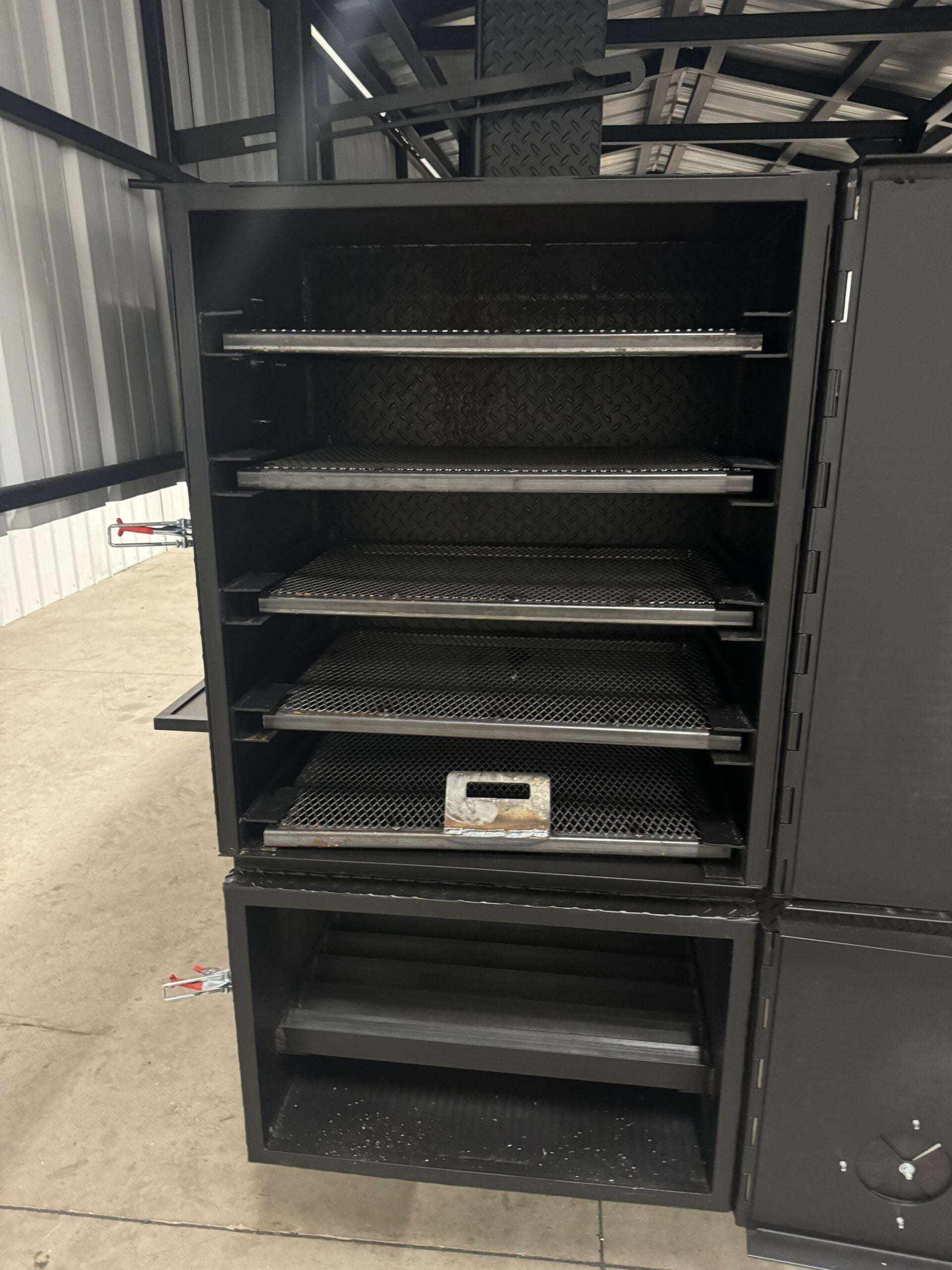 Commercial Custom Ultimate Smokehouse 72-inch smoker with multiple pull-out cooking racks and insulated firebox in an indoor warehouse setting