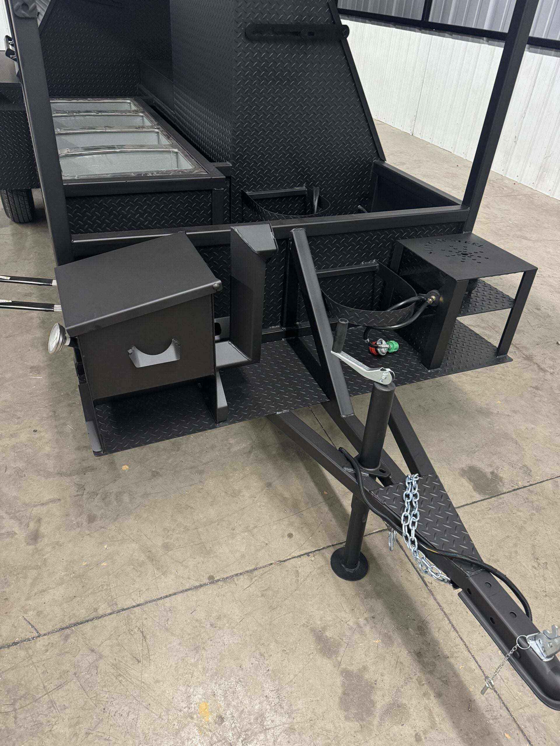 Custom Ultimate Smokehouse 72-inch commercial smoker trailer with charcoal grill, propane griddle, insulated firebox, and sink package
