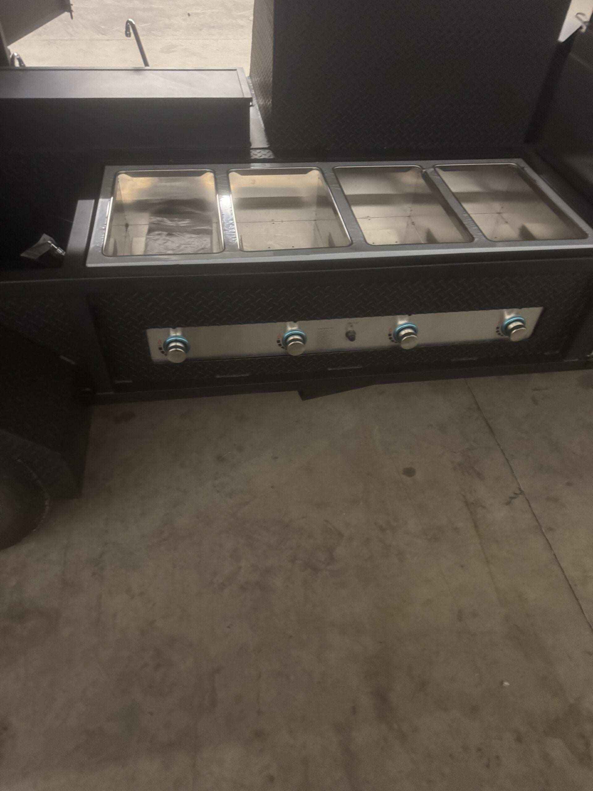 Ultimate Smokehouse 72 smoker trailer sandwich prep refrigeration with four compartment steam table and control knobs