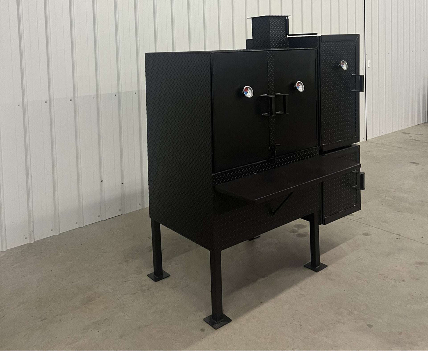 SNS 40 Cabinet vertical smoker with large 30x40 main chamber, triple racks, heavy-duty black steel construction, and insulated firebox.