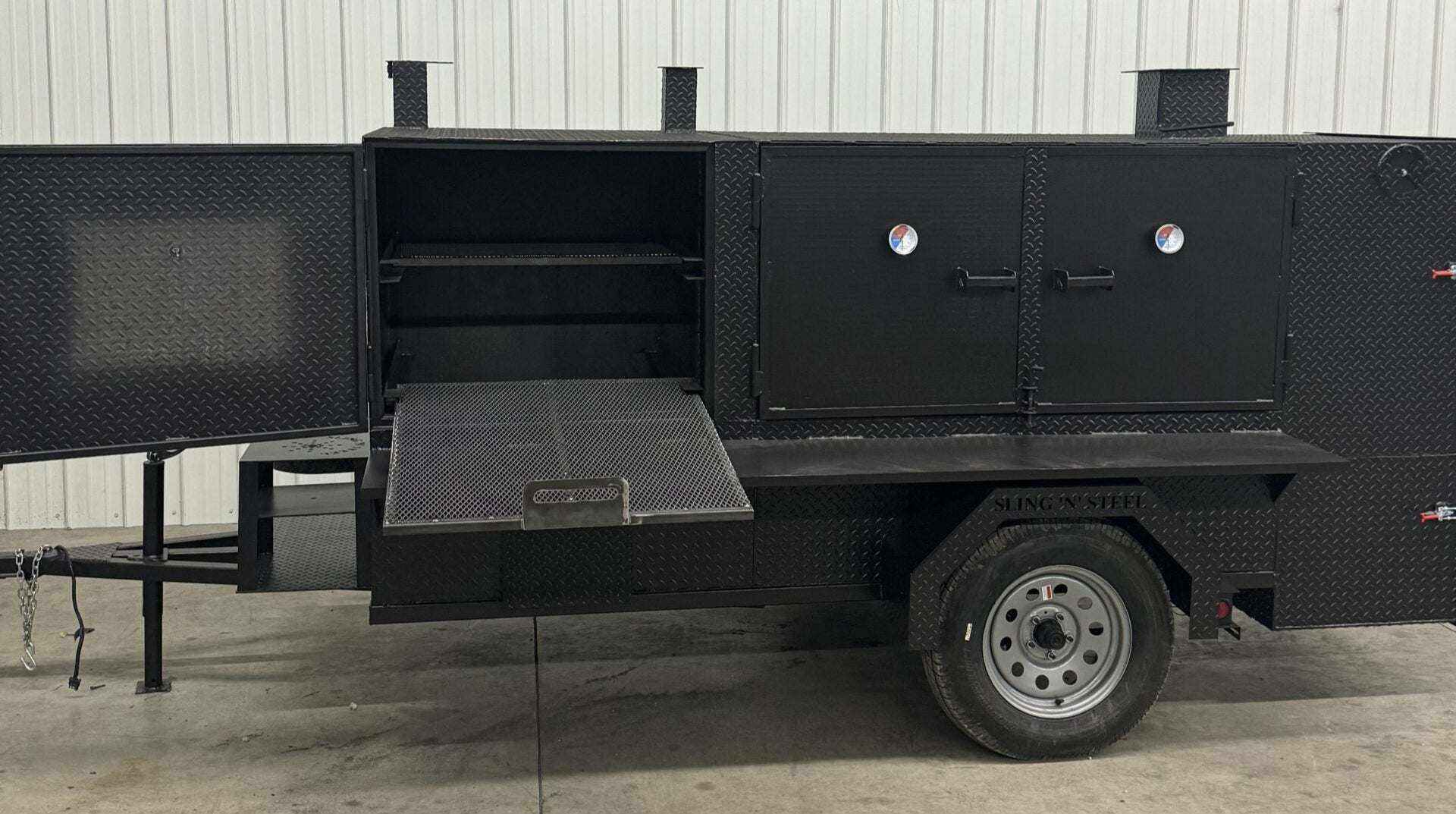 SNS 4060 Cabinet Smoker with multiple cooking racks and charcoal grill on a trailer for commercial catering use