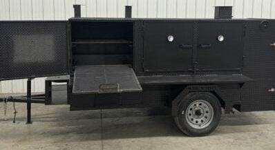 Custom barbeque pits SNS 4060 Cabinet Smoker with charcoal grill and multiple cooking racks on a trailer for large-scale catering.