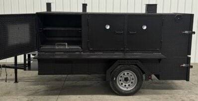 SNS 4060 black cabinet smoker with charcoal grill on trailer, featuring multiple cooking racks and firebox for large-capacity catering