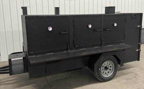 SNS 4060 Cabinet Smoker with charcoal grill, slide out racks, and insulated firebox on a trailer for commercial smoking and grilling
