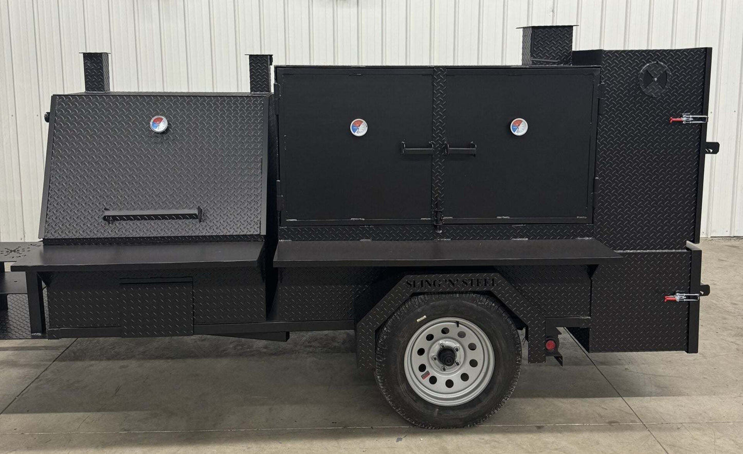 Black SNS 4060 smoker grill and cabinet main chamber with dual fryer stands and wheels for catering use
