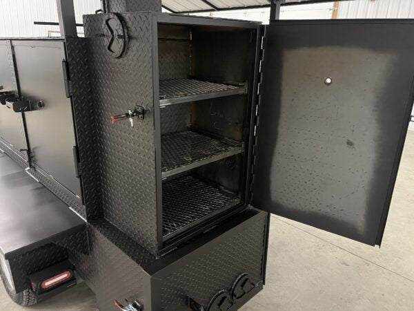 SNS 60 Cabinet Smoker with diamond tread steel construction, three slide-out cooking racks, insulated firebox, charcoal grill, fold-down roof, and sink package for commercial BBQ catering.