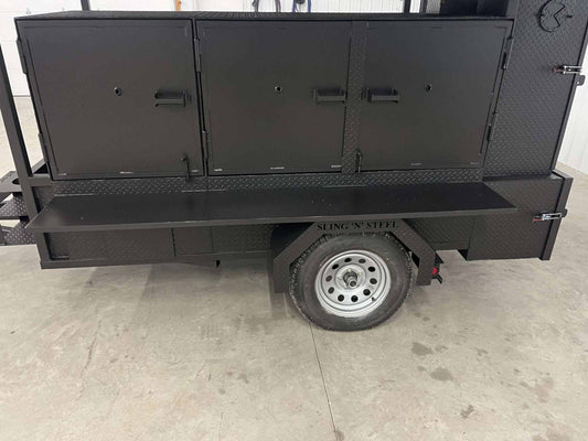 Black SNS 60 Cabinet Smoker and grill combo trailer with multiple doors, smoker compartments, and single wheel on concrete floor