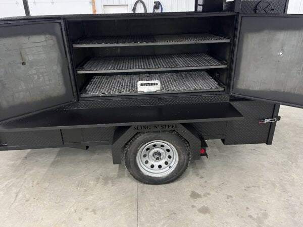 Commercial SNS 60 smoker cabinet with three slide out cooking racks on a trailer with roof package and sink.