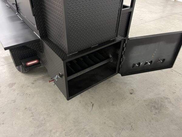 Open black diamond tread steel smoker cabinet compartment with slide out racks on concrete floor