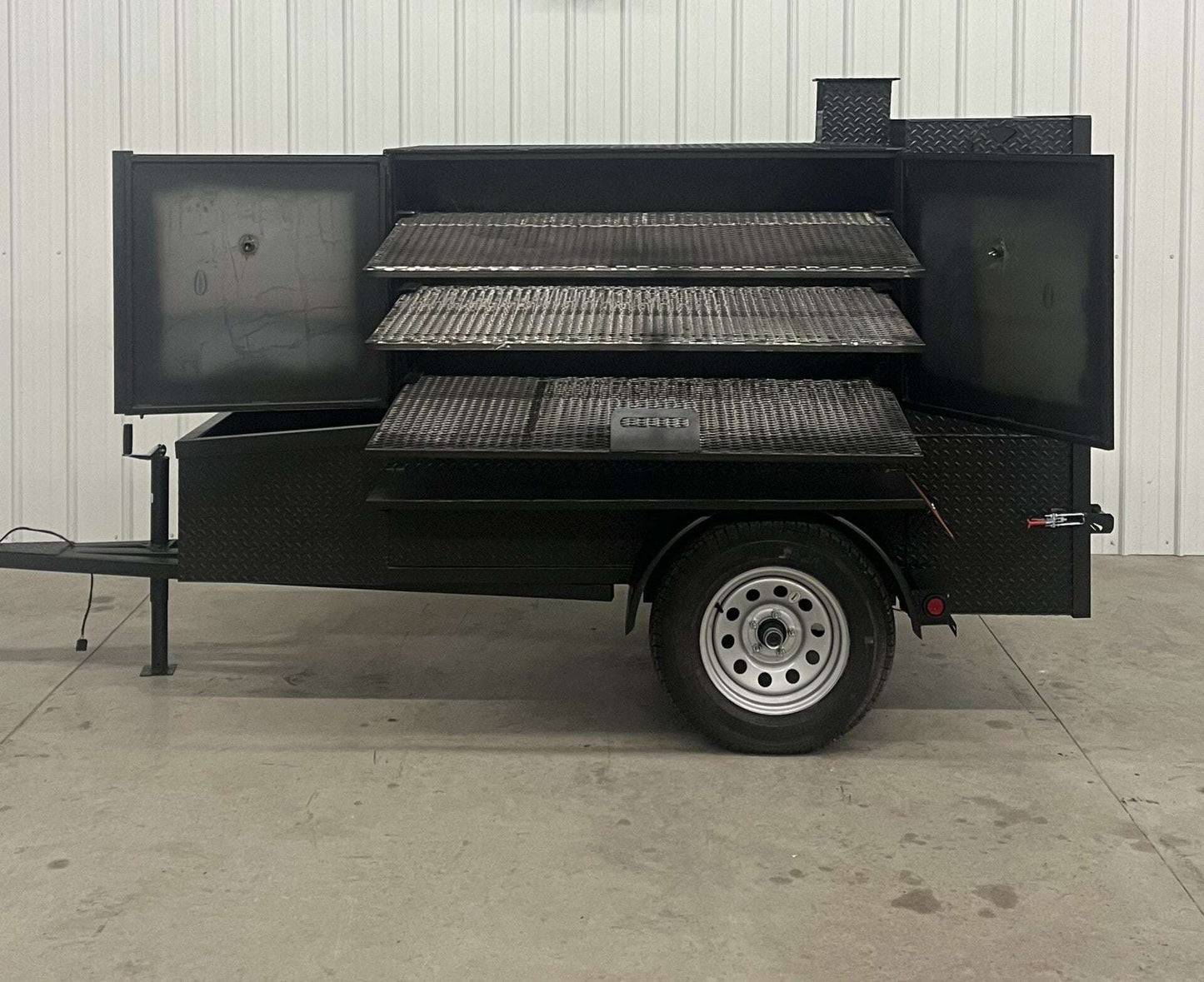 SNS 60 Cabinet Trailer Smoker with three slide-out racks and insulated firebox on single axle trailer