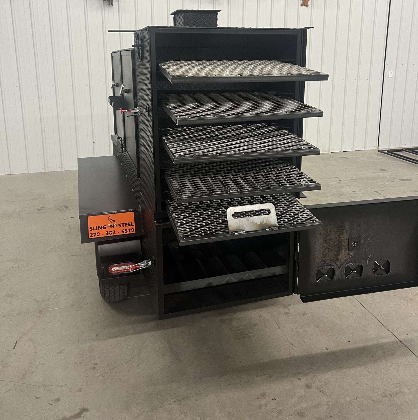 SNS 60 Cabinet Trailer Smoker with multiple slide-out cooking racks and insulated firebox in a metal design