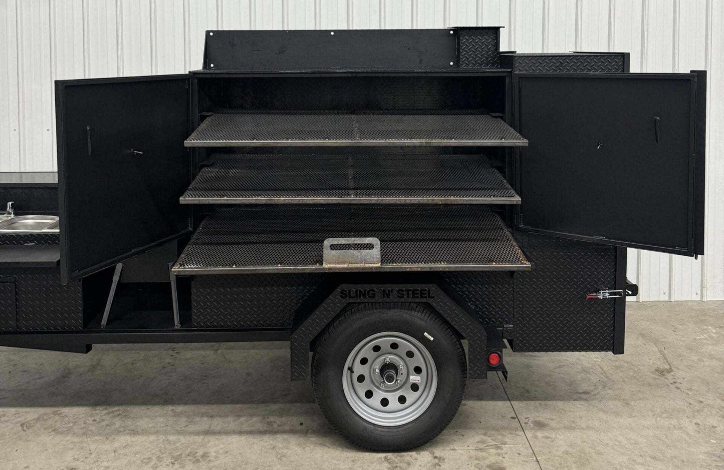 SNS 60 inch diamond tread steel smoker cabinet with three slide out cooking racks and attached sink with hot water system.