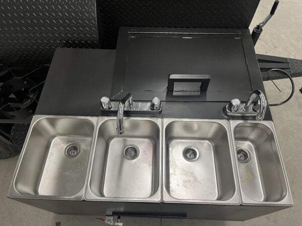 Stainless steel 3-bay sink with hand wash station and faucets on SNS Barrel 60 catering trailer with offset smoker barrel lid
