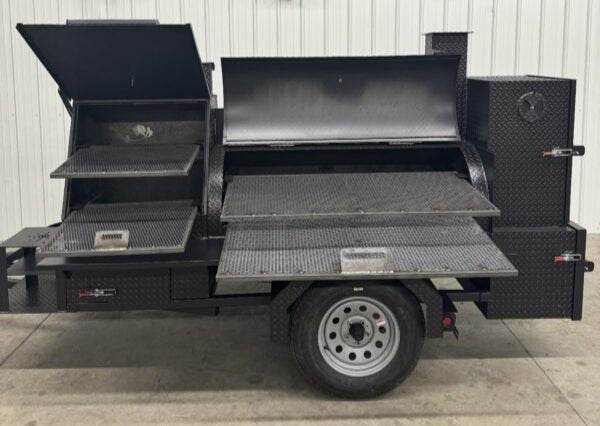Offset Smoker SNS Barrel 60 catering trailer with multiple cooking racks, insulated firebox, charcoal grill, and three-bay sink package.