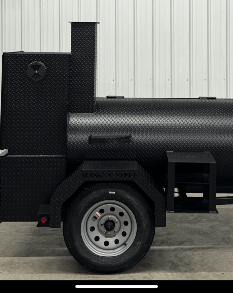 Black SNS Barrel 60 reverse flow smoker and charcoal grill trailer with insulated firebox and cooking racks on a single axle.