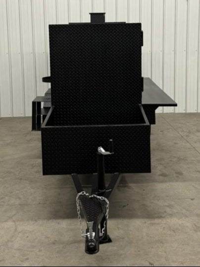 Large black SNS Beast Cabinet Smoker with diamond tread steel exterior and trailer hitch in an indoor setting