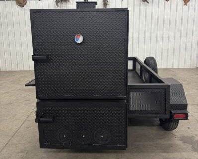Black SNS Beast Cabinet wood smoker with full length storage and mounted spare tire on trailer frame