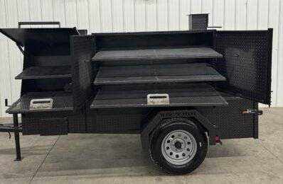 SNS Cabinet 60 Catering Trailer BBQ pit with sink package and multiple slide-out cooking racks on a diamond tread steel trailer