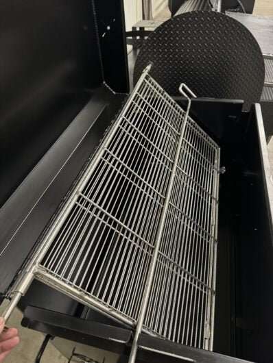 Custom Pits SNS Competition 60 smoker with 42-inch rotating double-sided stainless steel grate and charcoal firebox for commercial BBQ catering.
