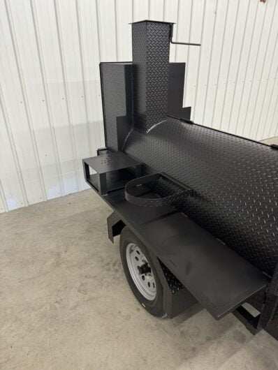 Custom Pits SNS Competition 60-inch charcoal and wood-fired commercial BBQ smoker with rotating stainless steel rack and insulated firebox on trailer.