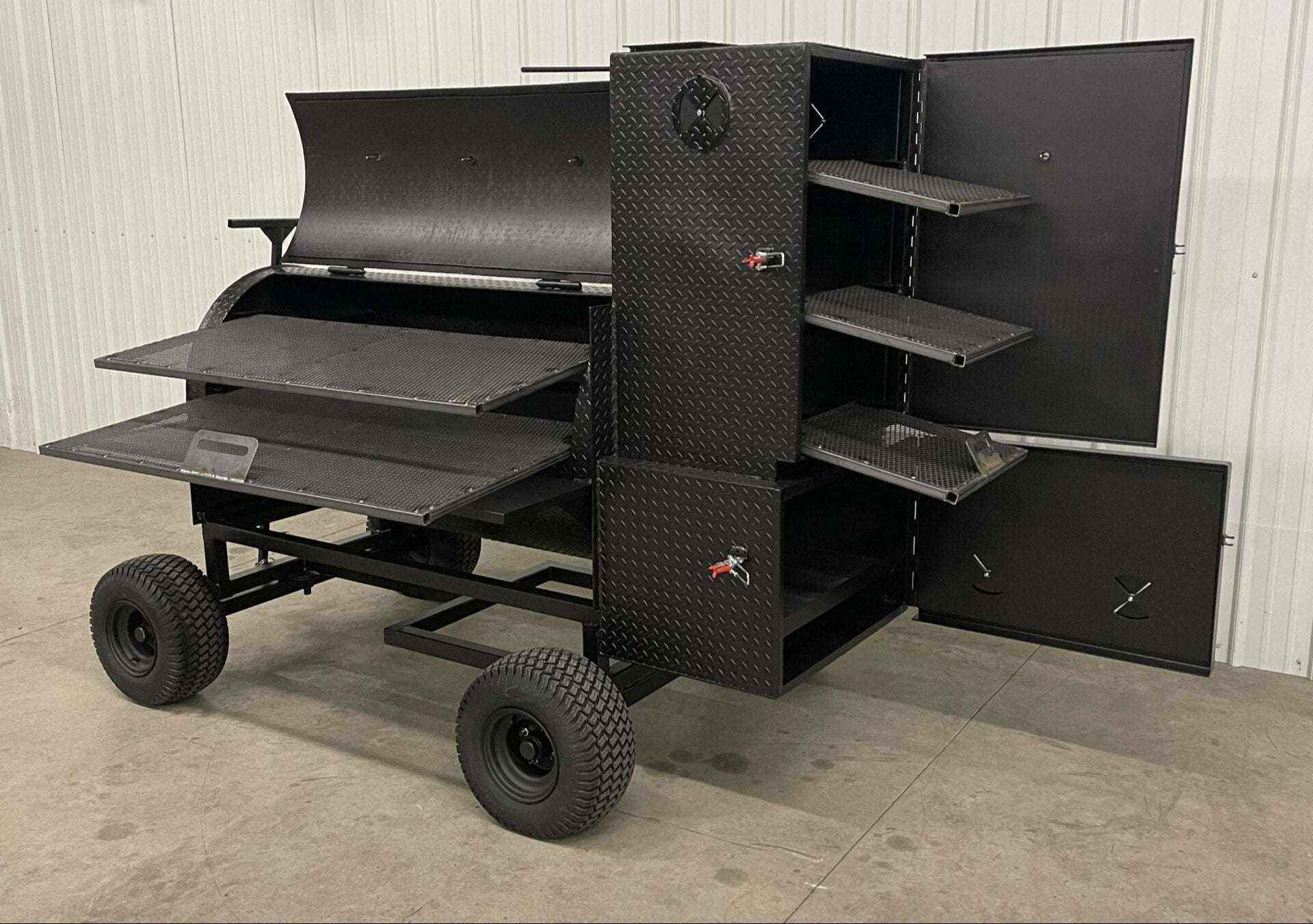 SNS Competition Smoker wagon-style grill with multiple cooking racks, insulated firebox, and black steel construction.