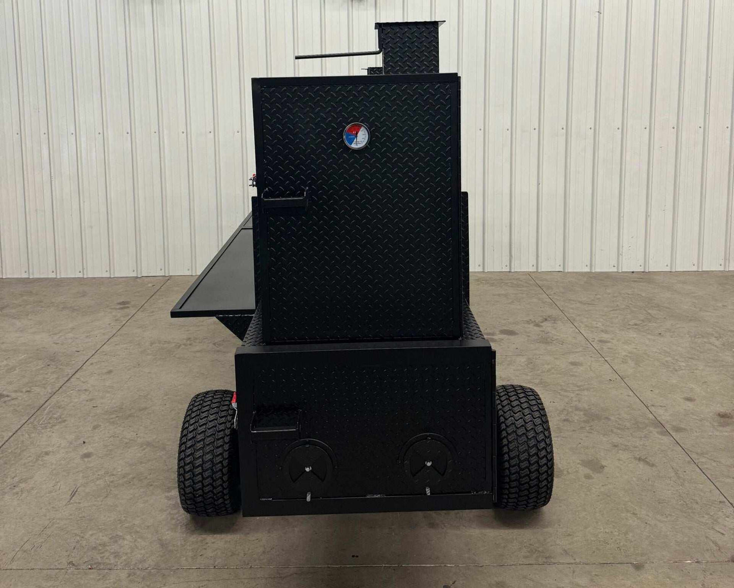 Black SNS Competition Wagon Backyard BBQ smoker with diamond tread steel, wheels, and pull handle designed for large capacity outdoor grilling and smoking.