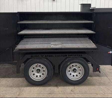 Open SNS Deluxe 72 Catering Trailer Smoker showing multiple cooking racks above dual wheels designed for versatile BBQ catering needs