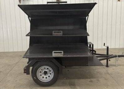 SNS Mega Grill grilling trailer with dual cooking pits and pull-out charcoal trays for commercial BBQ catering.