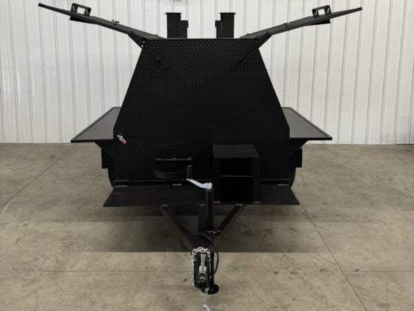 Front view of SNS Mega Grill black commercial grilling trailer with dual cooking pits and tow hitch.
