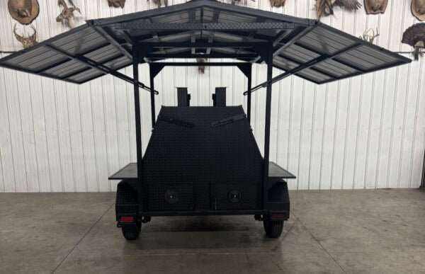 Giant Grill SNS Mega Grill commercial dual-pit cooking trailer with roof, charcoal trays, and LP tank holder for catering and BBQ events.