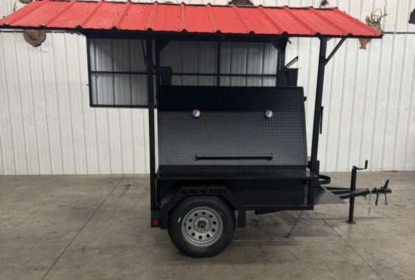 Black SNS Mega Giant Grill on trailer with red roof for mobile BBQ cooking and catering