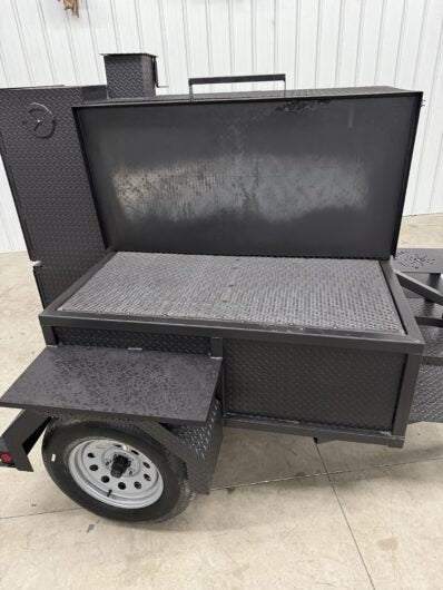SNS Smoke House Smoke Cabinet Smoker with large grilling surface, pull-out loading tray, and trailer-mounted for portability.