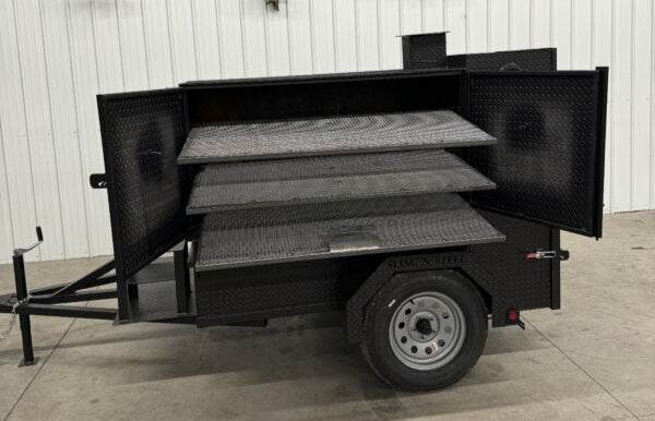 SNS Smoke House Smoke Cabinet smoker with large main chamber, three racks, and attached trailer for transportation