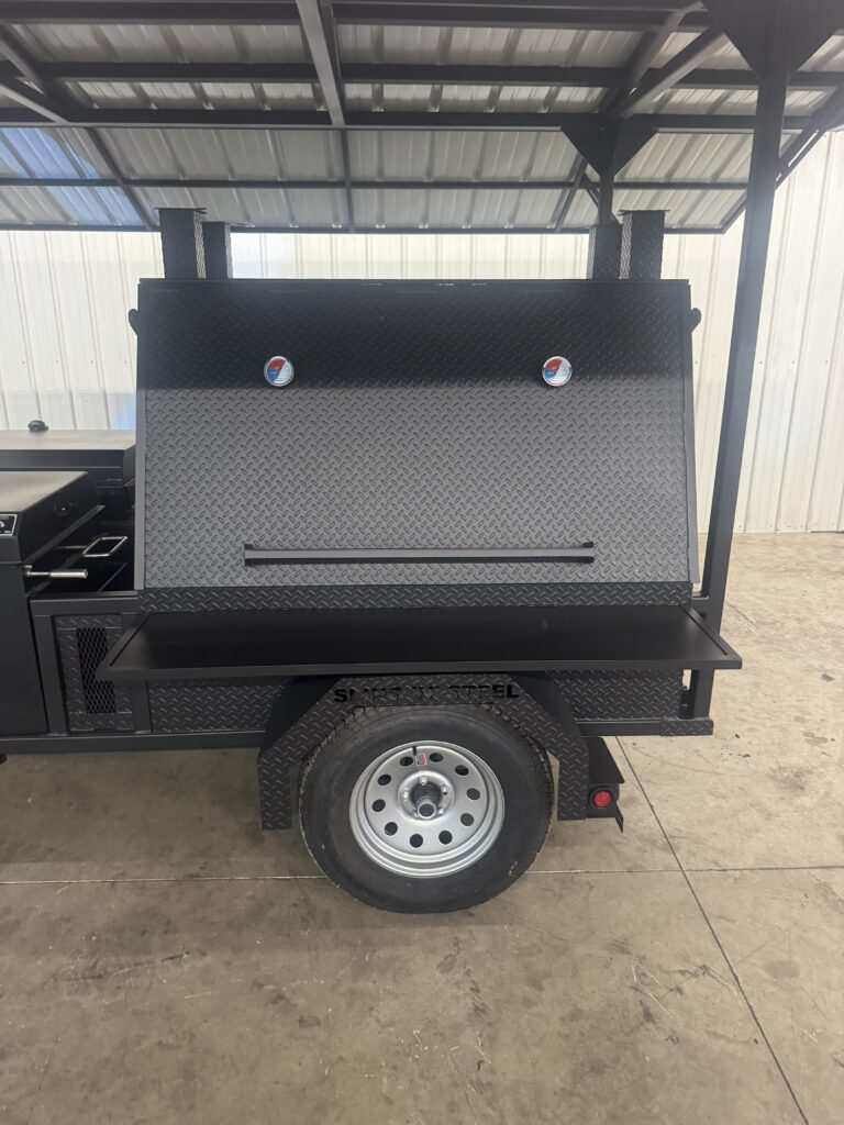 SNS Ultimate Mega Grill commercial charcoal grill trailer with roof, dual-sided main chamber, pull-out charcoal trays, rotating stainless steel racks, and tire-mounted base