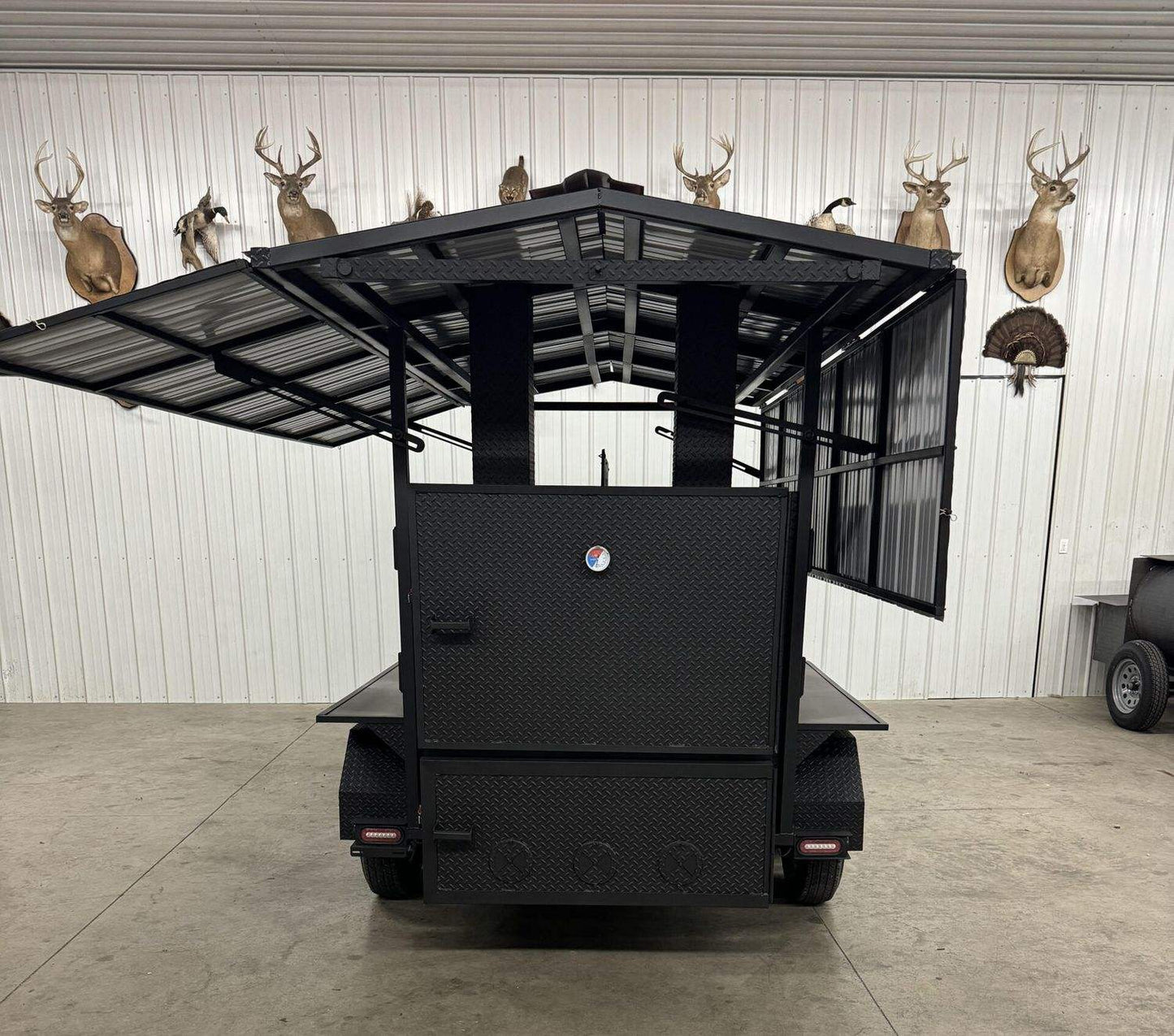 Commercial Avery Cabinet Smoker with large cooking chamber and open metal roof on trailer wheels for commercial use