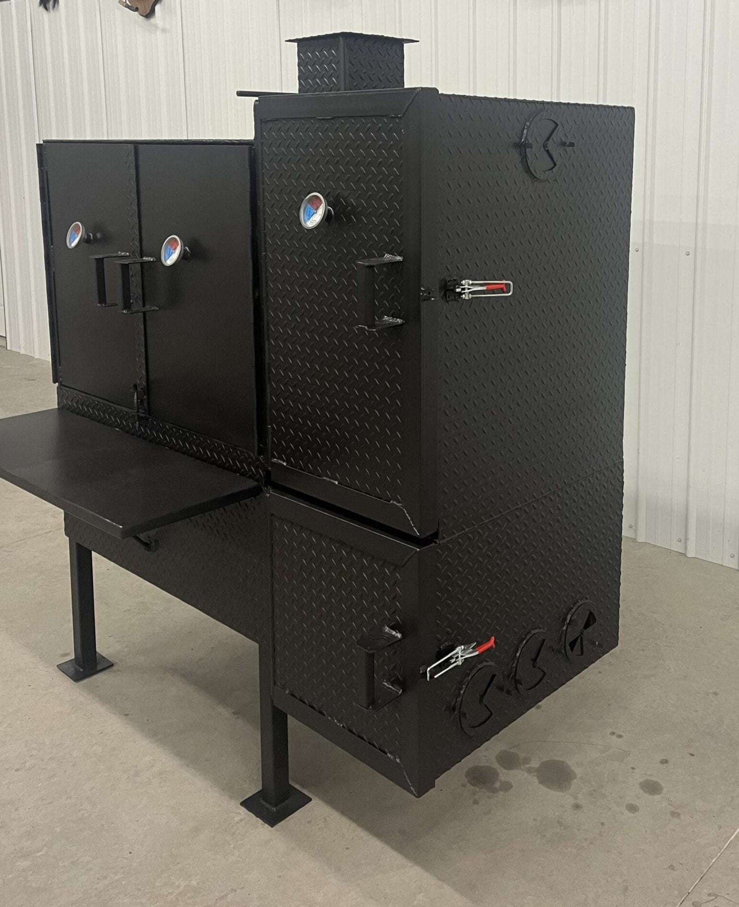 Black SNS 40 smoker cabinet with 30x40 main chamber, double-walled insulated firebox, and reverse flow design for large-capacity smoking.