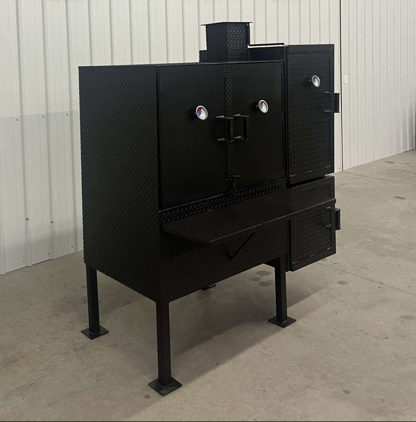 Large black SNS 40 smoker cabinet with double-walled insulated firebox and temperature gauges on doors