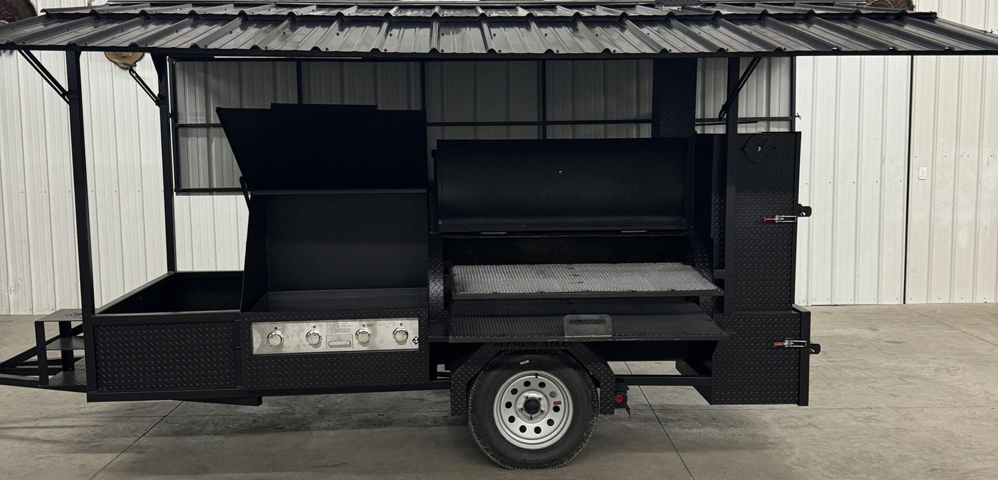 A black outdoor kitchen trailer with a corrugated metal roof and side prep table.