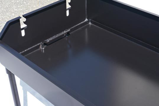 Black metal grill with a lid on a gray surface