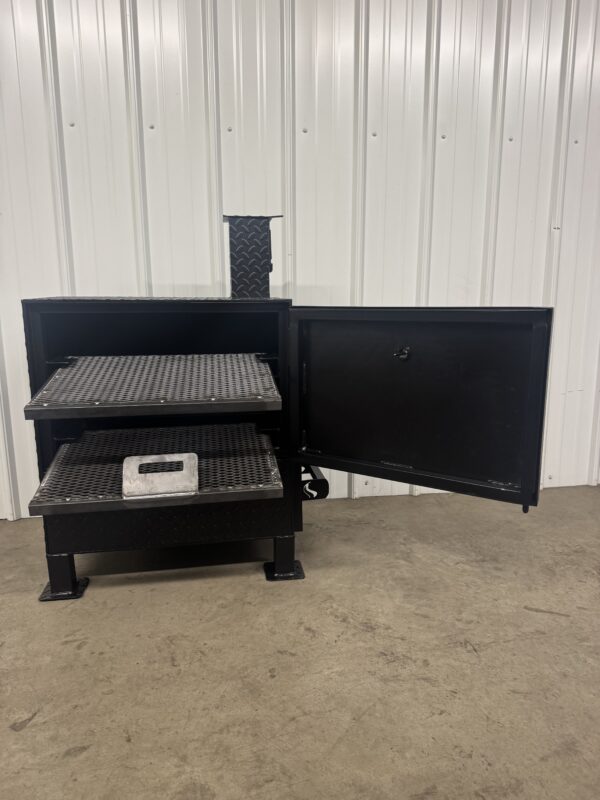 Black metal step stool with open cabinet door in a warehouse setting