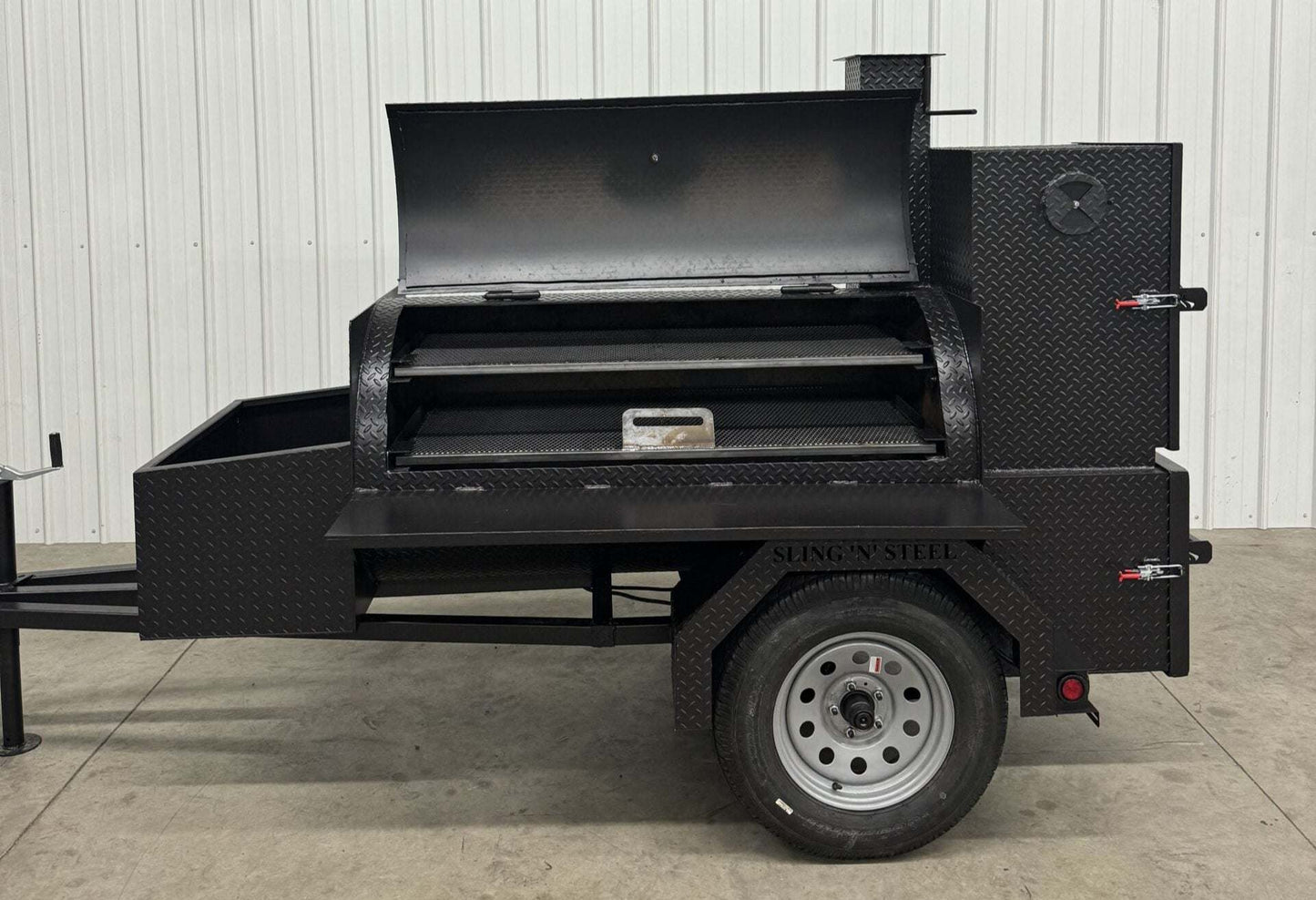 Competition 60 Barbeque Smoker with large main smoker tank, rib box, insulated firebox, storage basket, and fryer stand on trailer.