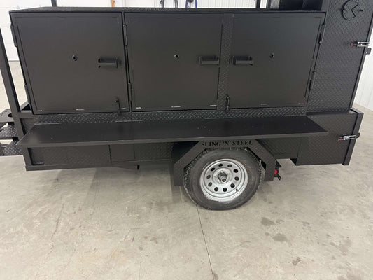 Black SNS 60 smoker cabinet and grill combo trailer with sink and fold-down roof package on a single axle with diamond tread steel finish